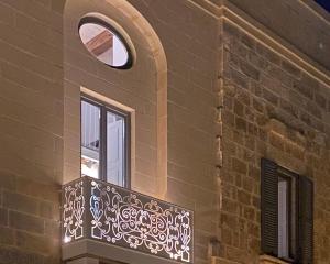 uma varanda num edifício de tijolos com uma janela em Casa Cara em Birgu