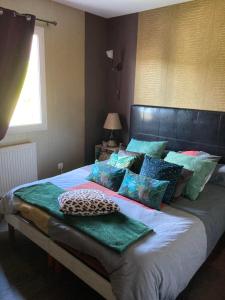 a bedroom with a large bed with pillows on it at BEAUN'MAISON Spa Piscine Borne électrique in Beaune