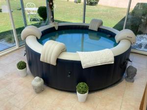 a large hot tub with headphones around it with plants at BEAUN'MAISON Spa Piscine Borne électrique in Beaune