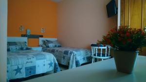 1 dormitorio con 2 camas y un jarrón de flores sobre una mesa en Hostal Don Jaime I y II, en Segovia