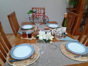 a table with plates and glasses and a bottle of wine at Casa flor da laranjeira in Ponte de Lima