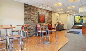 un bar con taburetes y una pared de ladrillo en Red Roof Inn Cleveland Airport - Middleburg Heights en Middleburg Heights