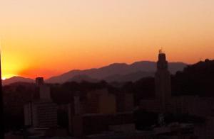 einen Sonnenuntergang über einer Stadt mit Bergen im Hintergrund in der Unterkunft Have A Nice Rio in Rio de Janeiro