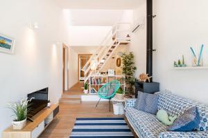 a living room with a couch and a staircase at Casa OSONA con jardin cerca de la Playa in Tarragona