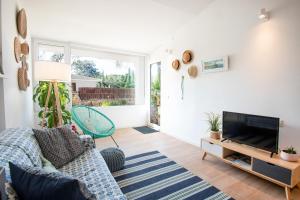 sala de estar con sofá y TV en Casa OSONA con jardin cerca de la Playa, en Tarragona