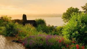 a garden with flowers and a body of water at Haus am See in Möhnesee