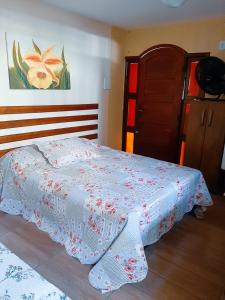 a bedroom with a bed with a blanket on it at Suites Oliveira in Arraial do Cabo