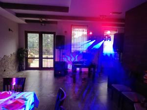 Къща за гости ДАЯНИЦА في Kopilovtsi: غرفة ذات أضواء أرجوانية وزرقاء في مطعم