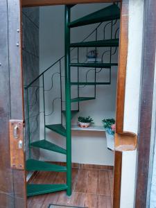 a green spiral spiral staircase in a room at Suites Oliveira in Arraial do Cabo