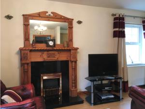 a living room with a fireplace and a mirror at Glenrandel Valley in Claudy