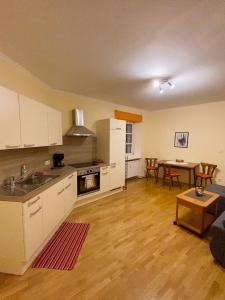 a kitchen with white cabinets and a table in a room at Rathausstüberl in Bad Radkersburg