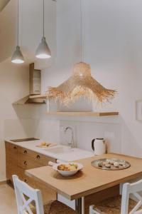 a kitchen with a table with a bowl of fruit on it at ERIEL Boutique Apartments in Lefkada Town