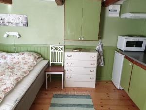a small kitchen with a bed and a microwave at Bergsgatan 64 in Gränna