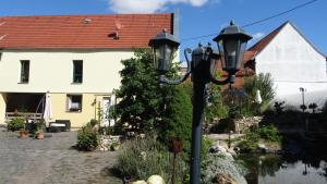 una luz de la calle frente a una casa y un río en Pension und Gästehaus Paffrath en Großbrembach