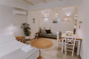 Cette chambre comprend un lit, une table et des chaises. dans l'établissement ERIEL Boutique Apartments, à Leucade