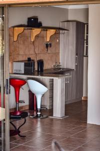 a kitchen with a counter with a microwave and stool at Quiet Getaway in Bloemfontein
