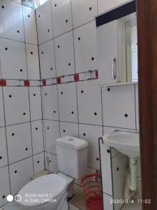 a bathroom with a toilet and a sink at Chalés Margarida in Ubatuba