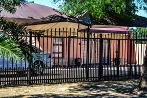 a black fence with a large umbrella in front of a building at Quiet Getaway in Bloemfontein