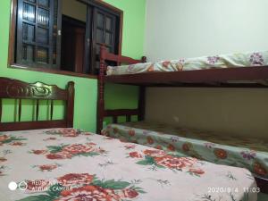 a bedroom with two bunk beds and a window at Chalés Margarida in Ubatuba