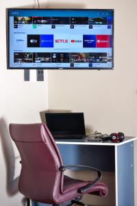 a computer desk with a chair and a monitor at Quiet Getaway in Bloemfontein
