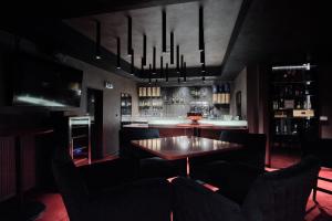 a dining room with a table and chairs and a bar at Hotel Aréna in Košice