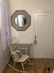 a rocking chair in a room with a mirror at Gîte St Thomas in Crépy-en-Valois