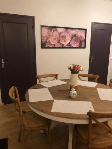 a wooden table with a vase of flowers on it at Gîte St Thomas in Crépy-en-Valois