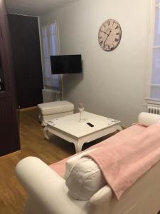 a living room with a couch and a clock on the wall at Gîte St Thomas in Crépy-en-Valois