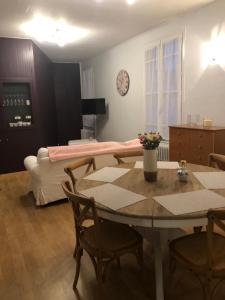 a living room with a table and a bed at Gîte St Thomas in Crépy-en-Valois