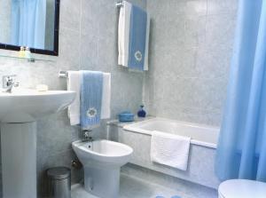 a bathroom with a sink and a toilet and a bath tub at Hotel El Puente in Sanxenxo