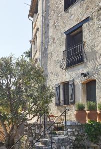a stone building with stairs and a window with plants at Luxury townhouse in the heart of medieval St Paul de Vence in Saint Paul de Vence