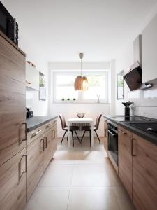 a kitchen with wooden cabinets and a table in it at Charming LOUISE in Saarbrücken