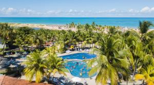 a beach with palm trees and palm trees at Pratagy Acqua Park Beach All Inclusive Resort - Wyndham in Maceió