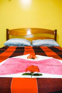 a bed with a pink blanket and flowers on it at Casa do Mestre Avila in Jijoca de Jericoacoara