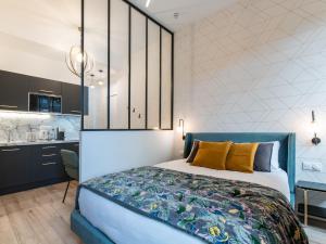 a bedroom with a king sized bed and a kitchen at Luxury Studio "Le Chaleureux" - Lyon Part-Dieu - Dreamy Flat Lyon in Lyon