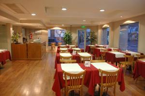 a restaurant with tables and chairs with red table cloth at Hotel colon in Junín