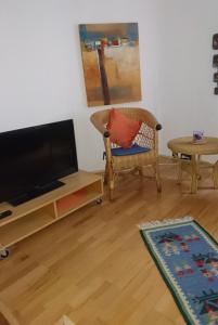 a living room with a flat screen tv and a chair at Down-Town-Oasis in Düsseldorf