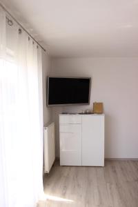 ein Wohnzimmer mit einem TV an einer weißen Wand in der Unterkunft Ferienwohnung Miletta, Zentral Friedrichshafen Bodensee in Friedrichshafen