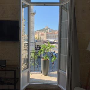 an open window with a potted plant on a balcony at Vieux Port République Cannebiére in Marseille