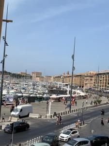 a group of cars parked in a parking lot with a harbor at Vieux Port République Cannebiére in Marseille