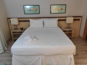 a bedroom with a large white bed with two lamps at Apart Hotel - Esplanada dos Ministérios - Centro de Brasília in Brasilia