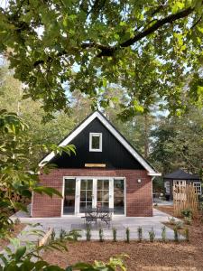 een zwart huis met een picknicktafel ervoor bij 't Edelhert in Nunspeet