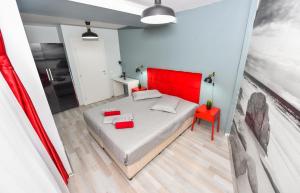 1 dormitorio con cama roja y silla roja en Ideal Accommodation Old Town, en Bucarest