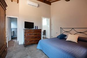 - une chambre avec un lit et une télévision sur une commode dans l'établissement Casa Ciaccheri 2, à Gaiole in Chianti