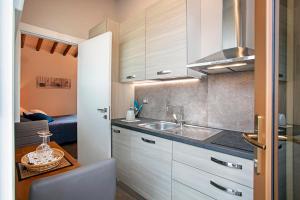 a kitchen with white cabinets and a sink at Casa Ciaccheri 2 in Gaiole in Chianti