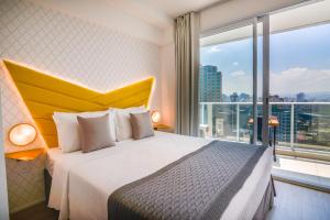 a hotel room with a bed and a large window at 360 Suítes Sé in São Paulo +274 photos