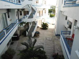 an alley between two buildings with blue and white stairs at Blue Star Apartments & Hotel in Lance aux Épines