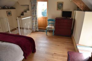 a bedroom with a bed and a dresser and a staircase at Delfryn Guest Suite in Haverfordwest