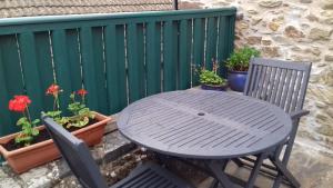 una mesa, sillas y macetas en un patio en Delfryn Guest Suite en Haverfordwest