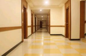 an empty hallway of a building with wooden doors at Hotel Chitra Park in Thiruchendur